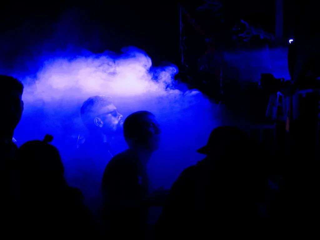 Blue-lit haze and silhouettes on the dancefloor at a Primal Effect club night