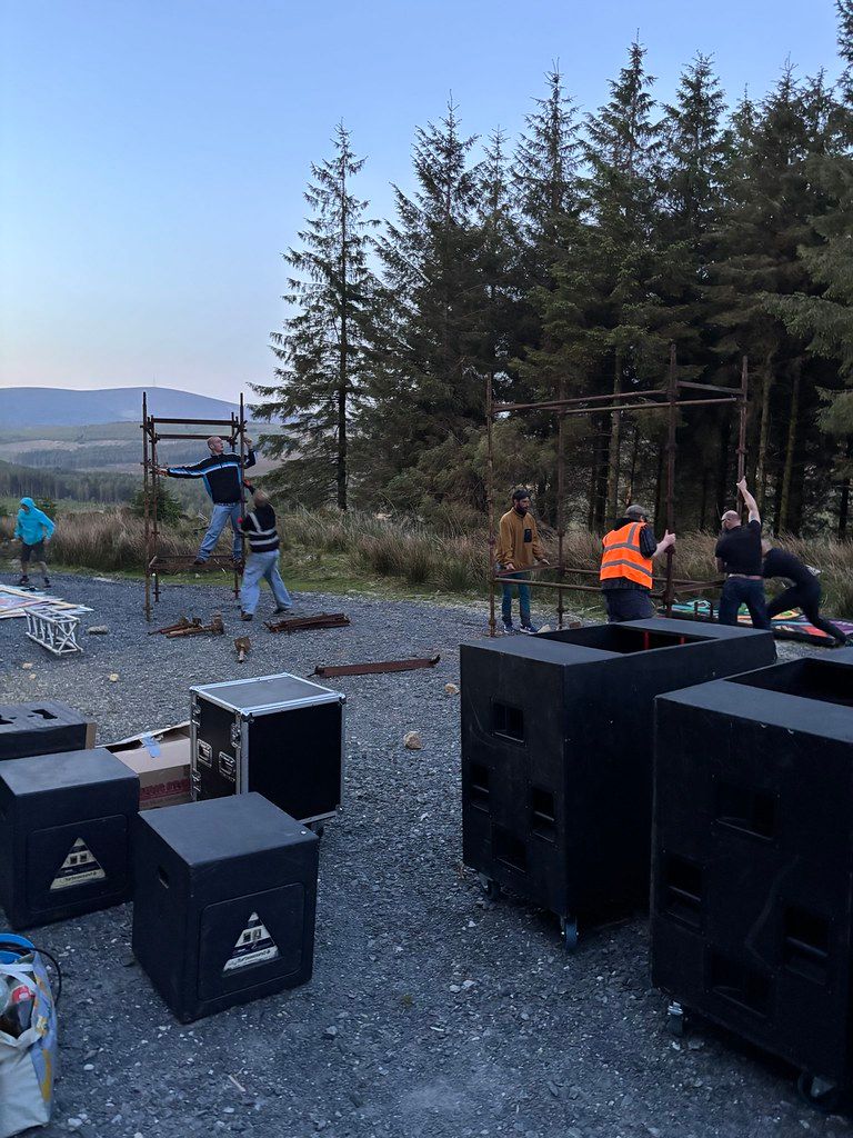 Daytime hilltop setup with mountains, rig and truss