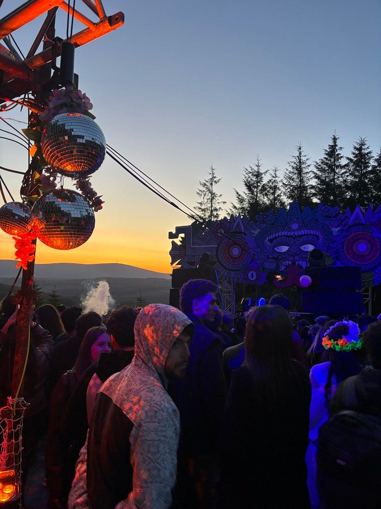 Sunset at festival with disco balls and crowd